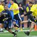 Alijah Bradley, out runs Donald Lessner during the Victors Classic alumni football game at Michigan Stadium on Saturday. Melanie Maxwell I AnnArbor.com